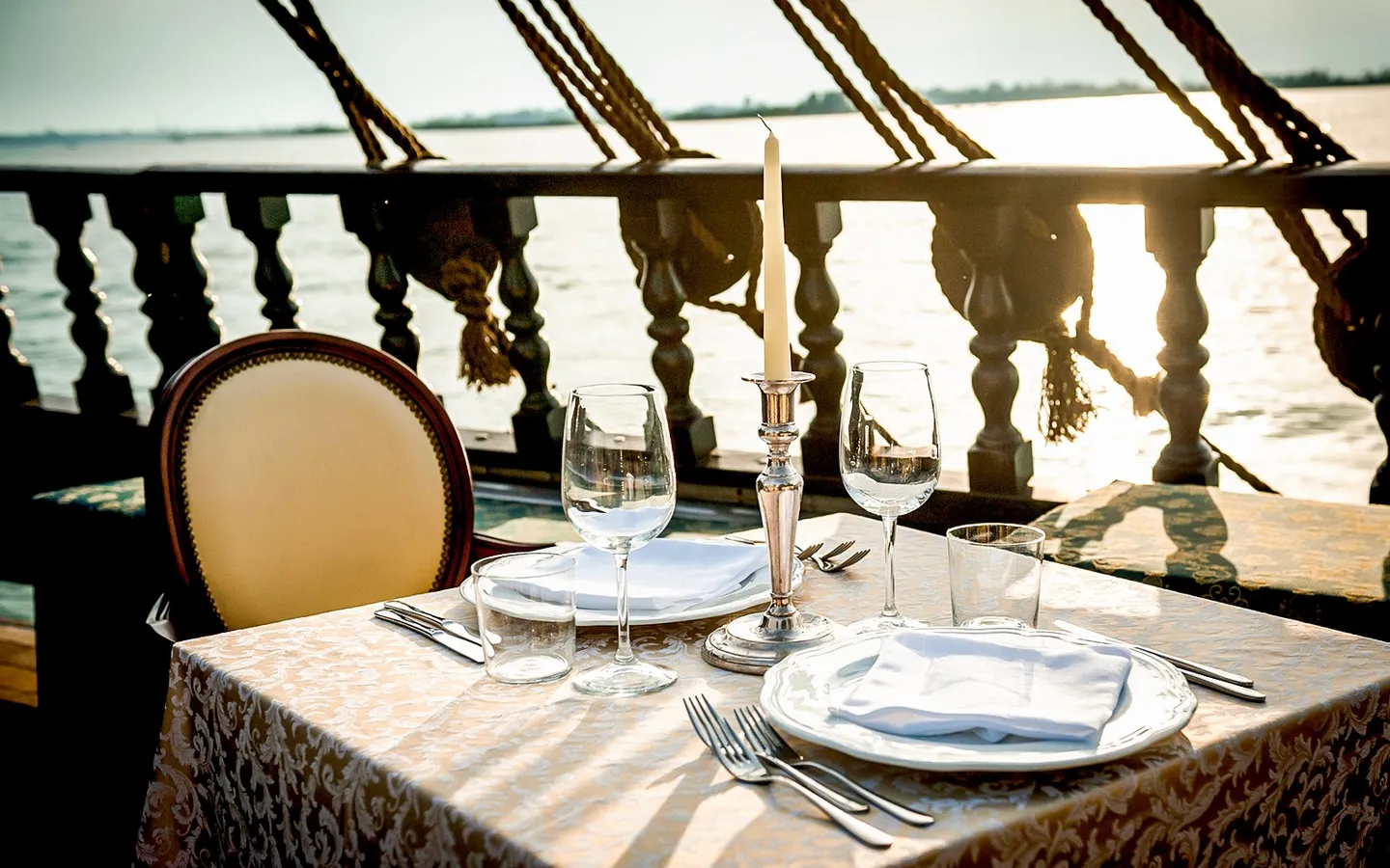 Table set for dinner aboard a galleon at sunset