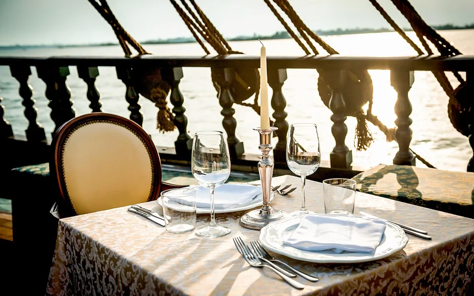 Table set for dinner aboard a galleon at sunset
