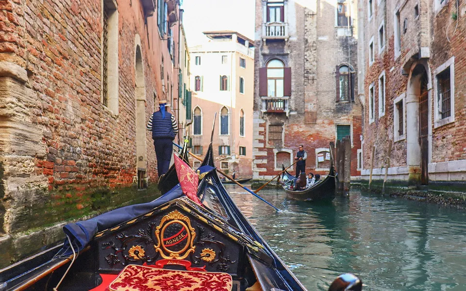View from a gondola under a small canal bridge