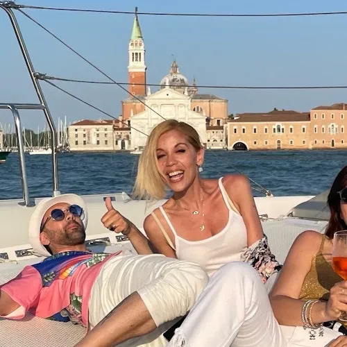 Guests relaxing on the catamaran with San Giorgio Maggiore behind them
