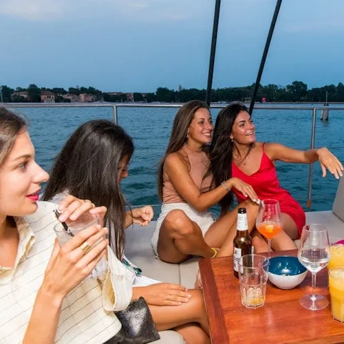 Guests enjoying drinks aboard the lagoon catamaran at dusk