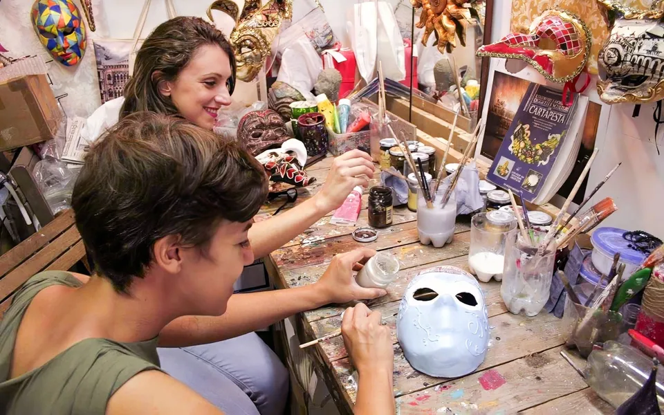 Participants decorating Venetian masks at a workshop