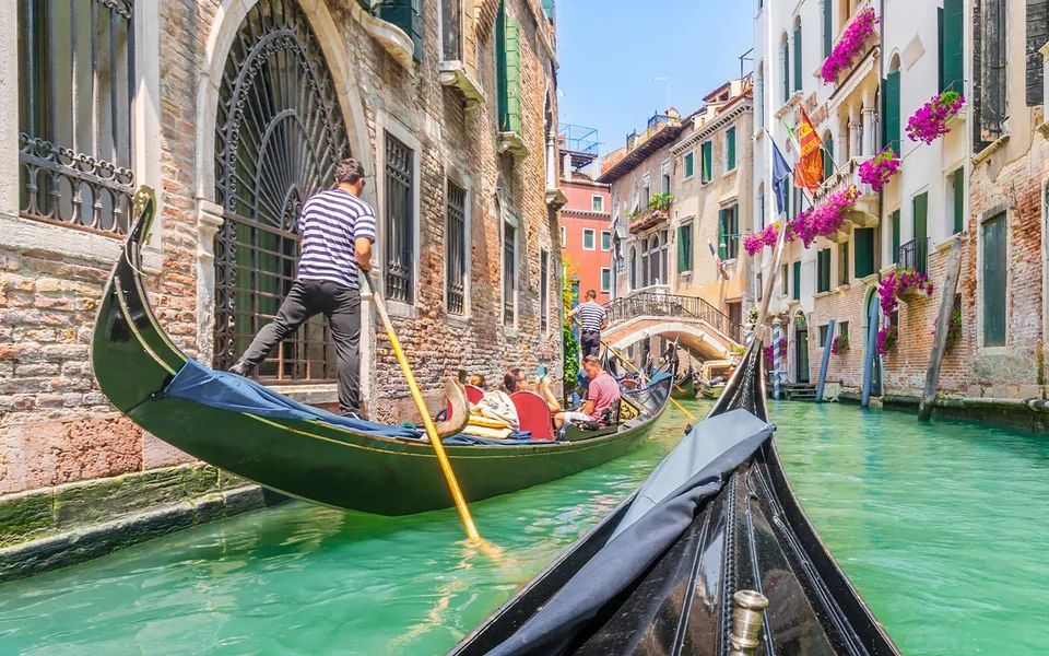 Gondoliers passing on a narrow Venice canal